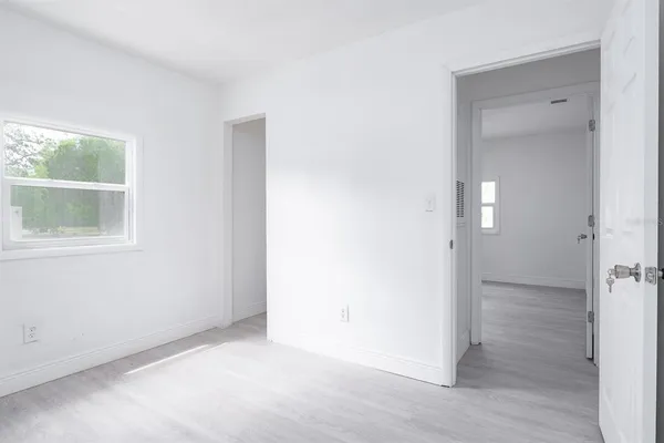 an empty room with wooden floor and a window