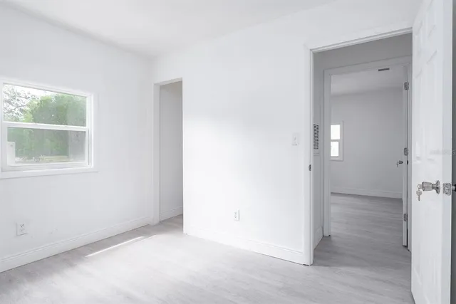 an empty room with wooden floor and a window
