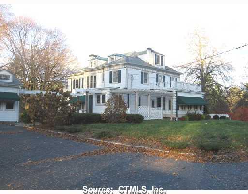 940 Orange Center Road Orange, CT 06477 - Photo 1 of 1 a view of a yard in front of a brick house with large windows