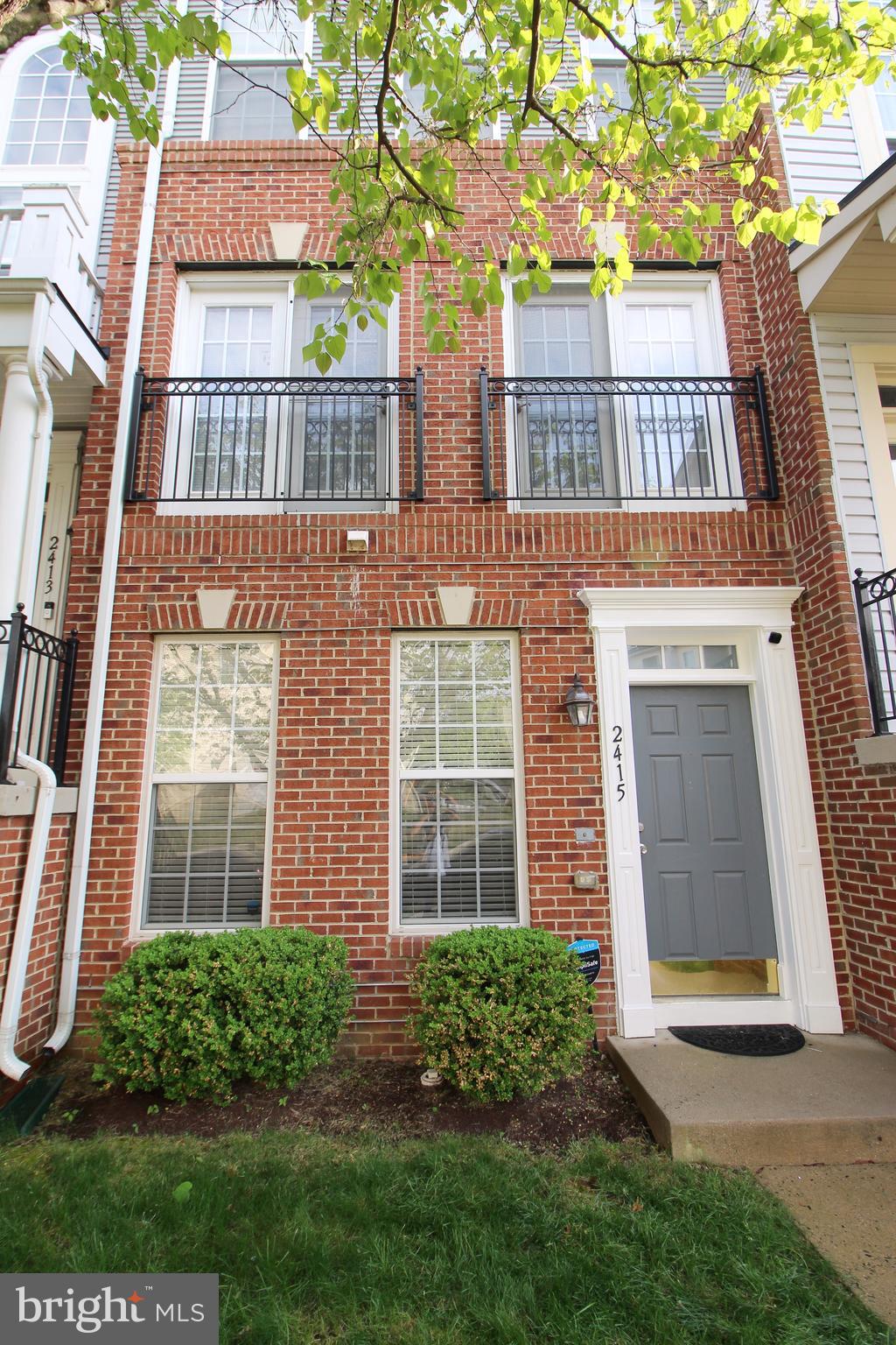 2415 Rainswood Lane Woodbridge, VA 22191 - Photo 2 of 29 a view of a brick building next to a yard