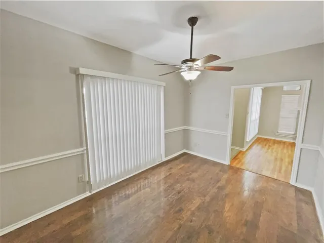 a view of an empty room with a chandelier fan