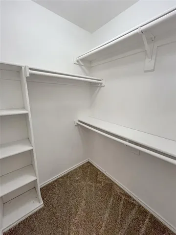 a view of an empty room with chandelier fan and table