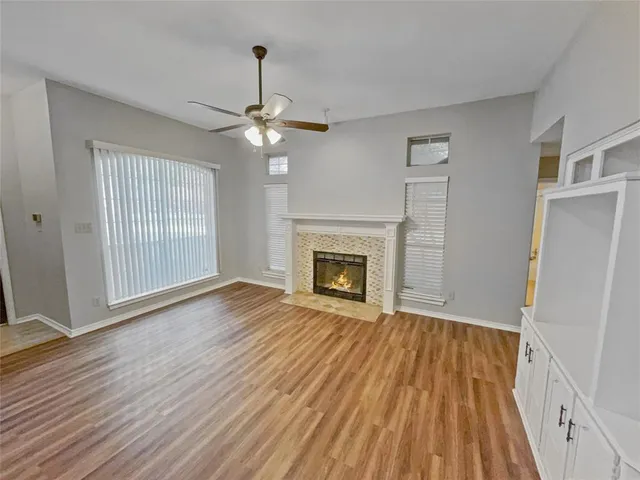 a view of a room with wooden floor and ceiling fan