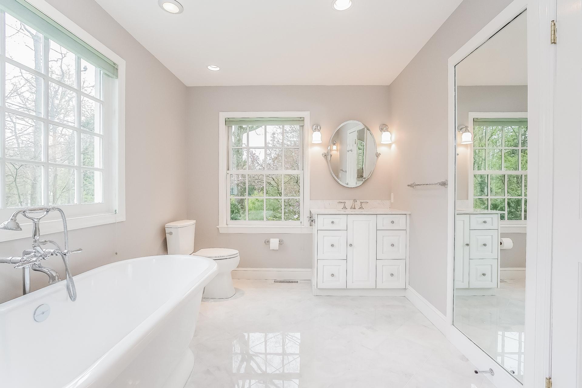 11 Pondfield Lane Darien, CT 06820 - Photo 14 of 31 a spacious bathroom with a double vanity sink a mirror and a bathtub next to a window