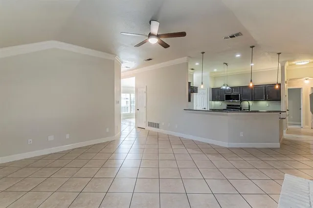 a view of a kitchen with kitchen island white cabinets and stainless steel appliances