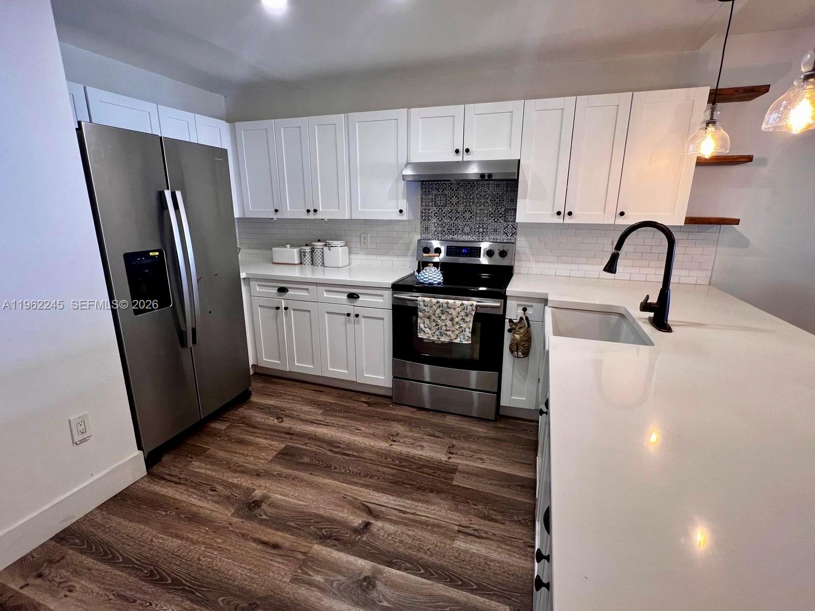 2551 West 64th Place Hialeah, FL 33016 - Photo 5 of 20 a kitchen with stainless steel appliances a refrigerator stove and sink