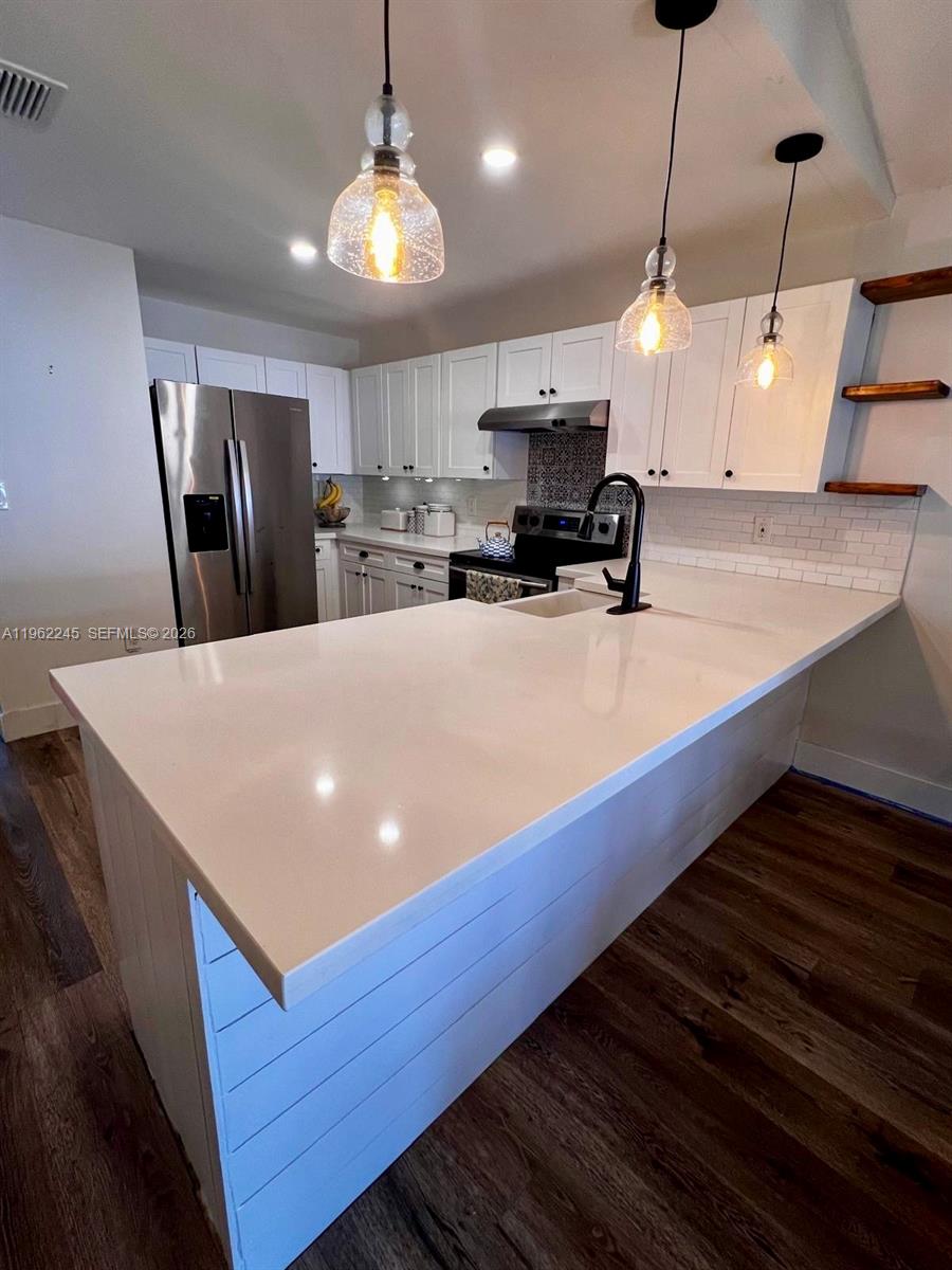 2551 West 64th Place Hialeah, FL 33016 - Photo 7 of 20 a large kitchen with stainless steel appliances a large center island attached withe living room