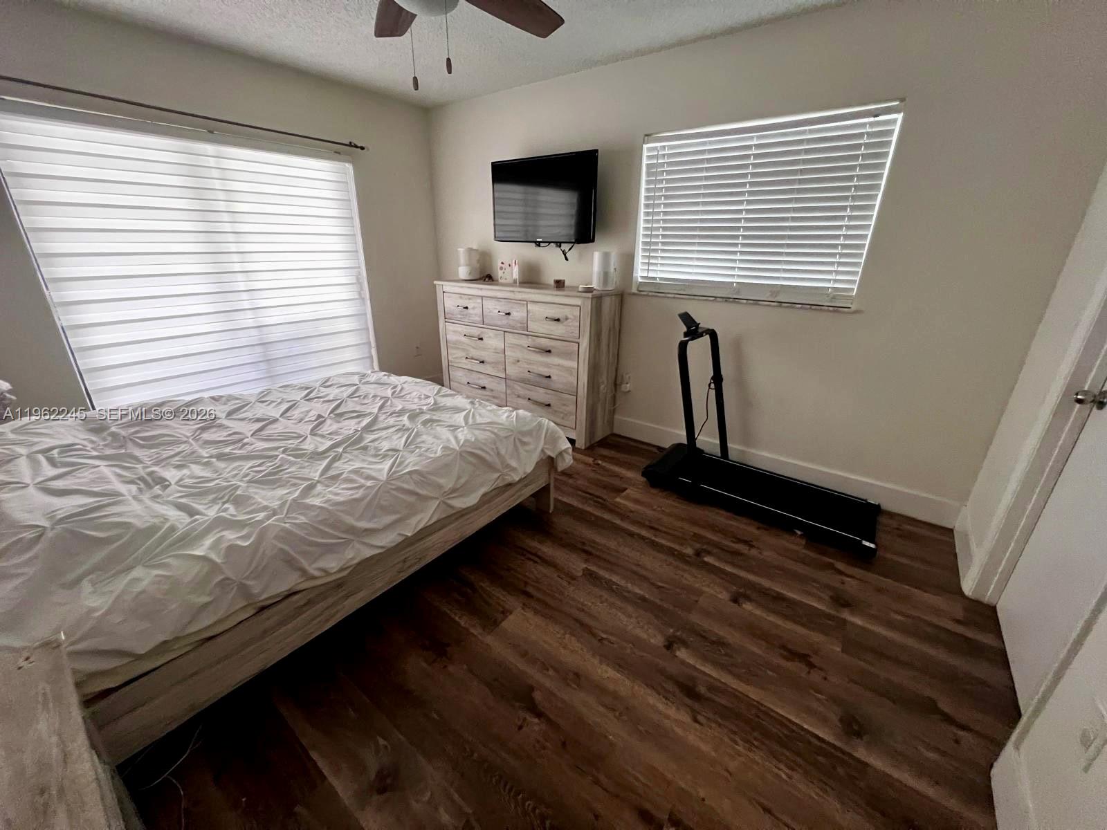 2551 West 64th Place Hialeah, FL 33016 - Photo 9 of 20 a bedroom with a bed next to a window with a flat screen tv