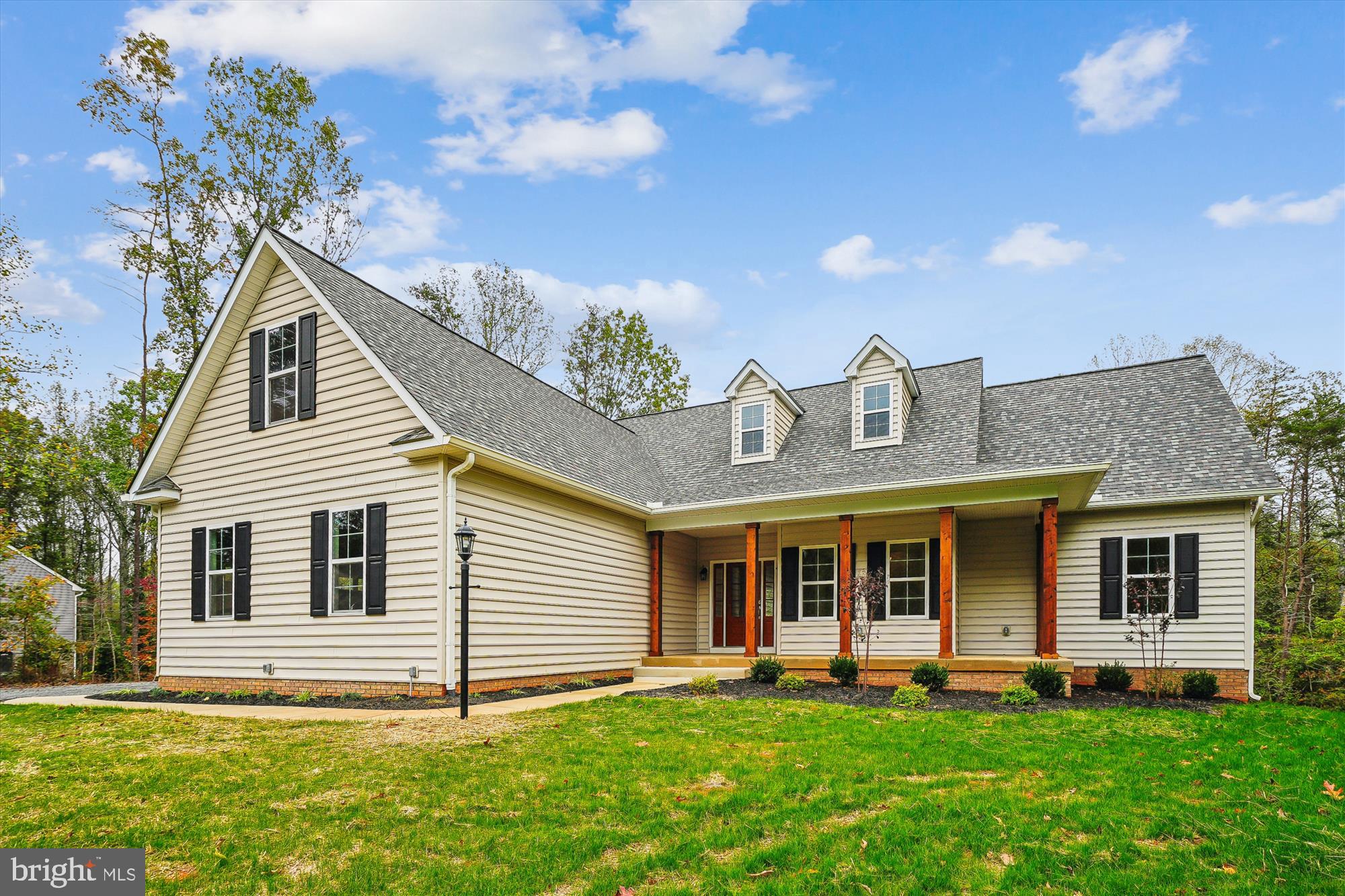 a front view of a house with a yard and trees