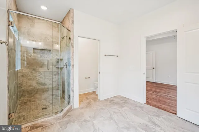 a bathroom with a shower and a glass door