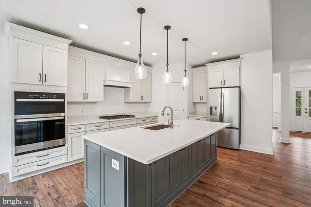 a kitchen with a stove a refrigerator and a sink