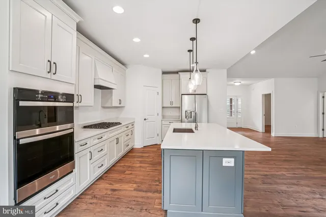 a large kitchen with stainless steel appliances kitchen island granite countertop a stove a sink and a refrigerator