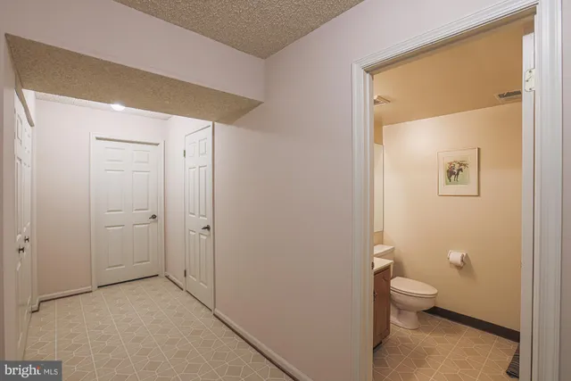 a bathroom with a granite countertop toilet and a sink