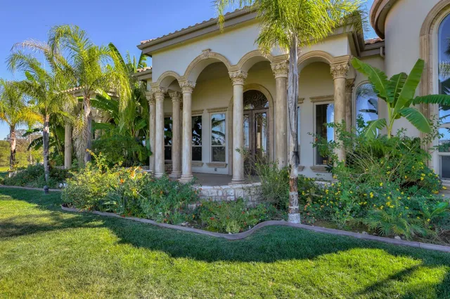 a living room with furniture chandelier and a large window