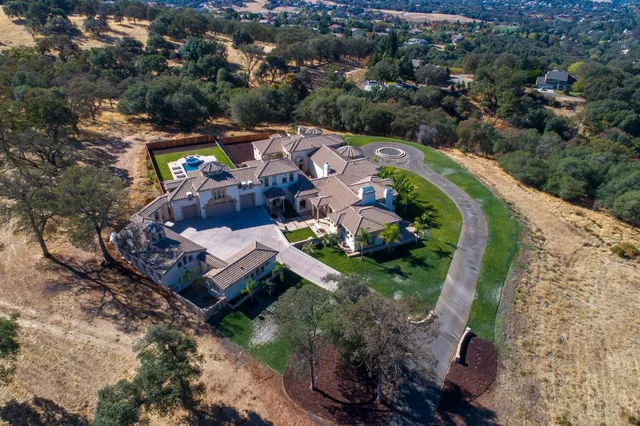a view of a house with a swimming pool and a yard