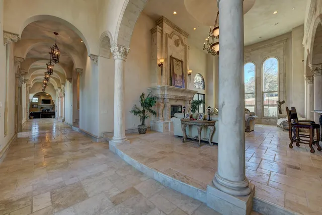 a view of a large dining room with wooden floor a chandelier a glass table and chairs