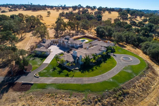 an aerial view of a house with a yard and balcony