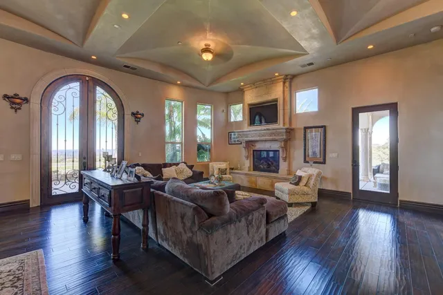 a view of a livingroom with furniture mirror and wooden floor