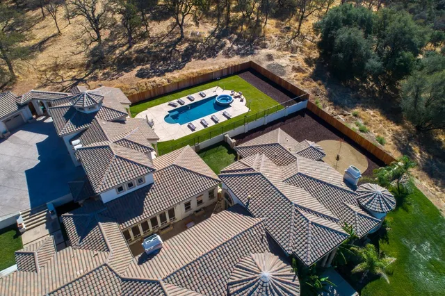 an aerial view of a house with swimming pool and mountain view