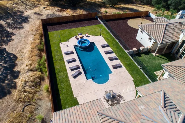 an aerial view of a house with garden space and outdoor seating