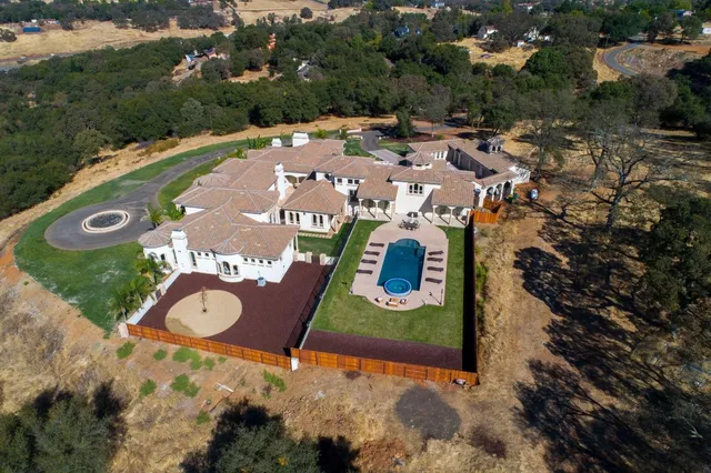 a view of a house with a small yard plants and palm trees