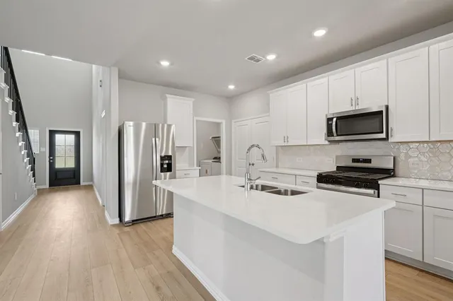 a kitchen with stainless steel appliances a refrigerator stove microwave and cabinets