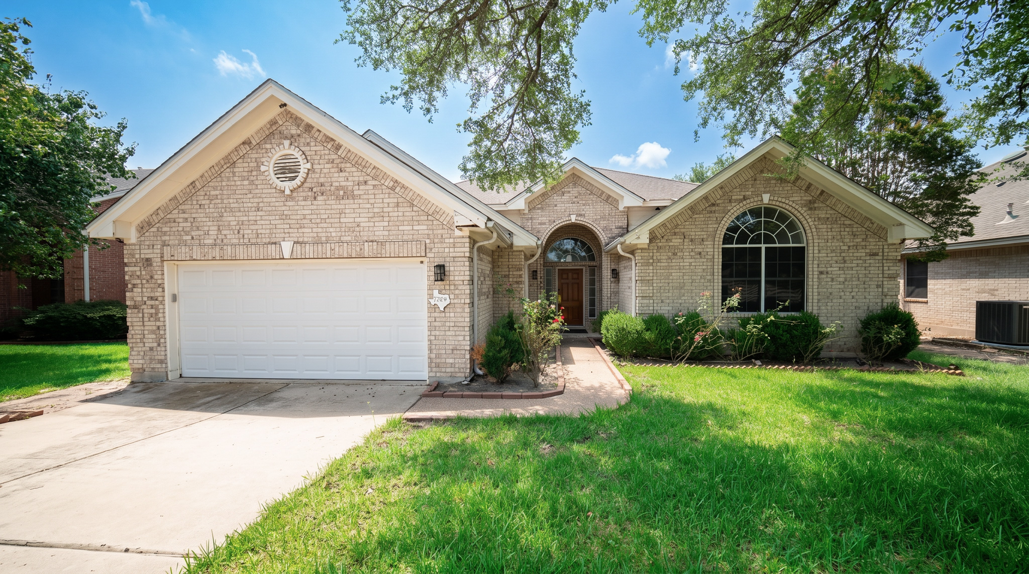 A classic brick exterior with a welcoming entryway and mature landscaping.