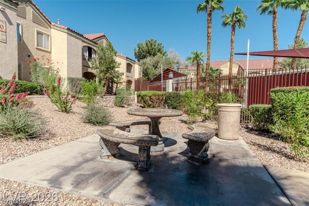 7885 West Flamingo Road, Unit 2171 Las Vegas, NV 89147 - Photo 21 of 22 An inviting stone picnic set awaits in a beautifully landscaped communal area.