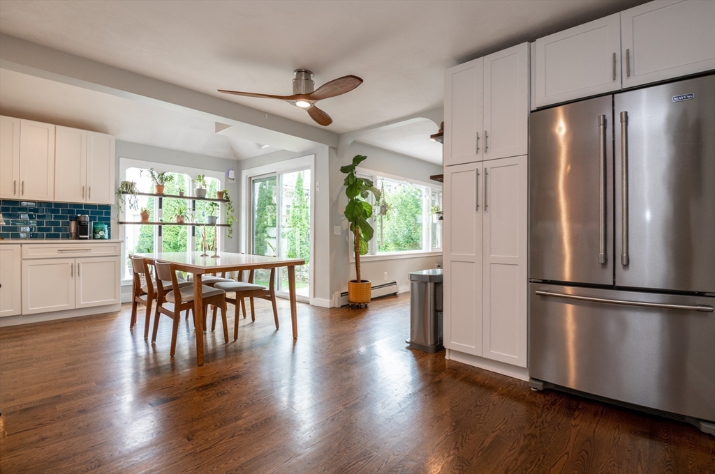 35 Central Street Middleton, MA 01949 - Photo 17 of 42 a kitchen with a refrigerator a microwave oven a dining table and wooden floor