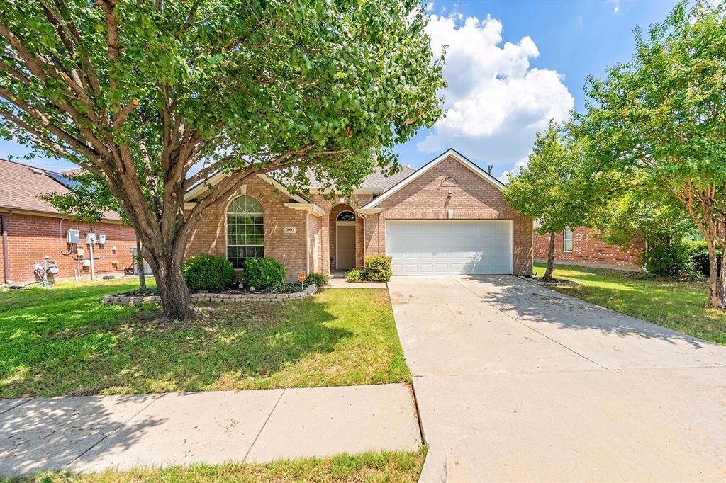 2609 Cowboy Trail Little Elm, TX 75068 - Photo 1 of 34 View of front facade featuring a front yard, driveway, brick siding, and an attached garage