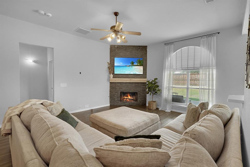 2609 Cowboy Trail Little Elm, TX 75068 - Photo 11 of 34 Living area featuring wood finished floors, a large fireplace, and ceiling fan