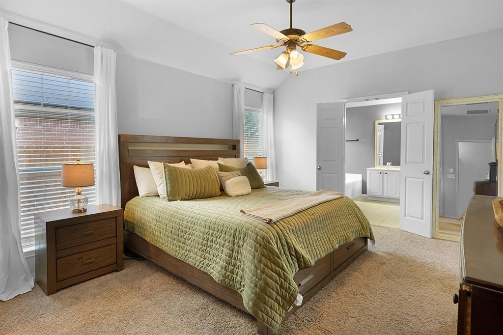 2609 Cowboy Trail Little Elm, TX 75068 - Photo 20 of 34 Bedroom featuring light colored carpet, lofted ceiling, ensuite bath, ceiling fan, and light tile patterned floors