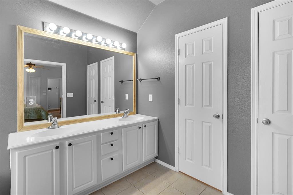 2609 Cowboy Trail Little Elm, TX 75068 - Photo 23 of 34 Full bathroom with light tile patterned floors, double vanity, a textured wall, connected bathroom, and ceiling fan