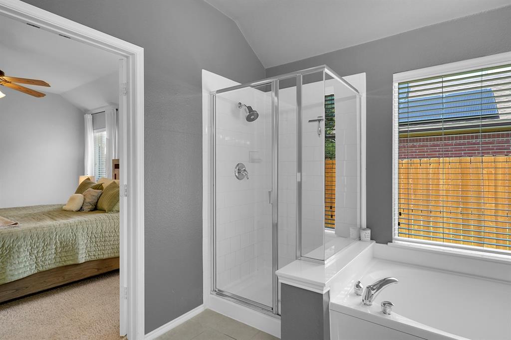 2609 Cowboy Trail Little Elm, TX 75068 - Photo 24 of 34 Full bath featuring lofted ceiling, ensuite bath, a stall shower, a bath, and light tile patterned floors