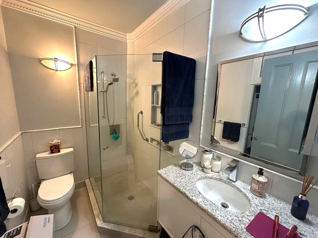 88 Charles Street, Unit 5 Boston, MA 02114 - Photo 11 of 15 a bathroom with a granite countertop sink toilet and shower