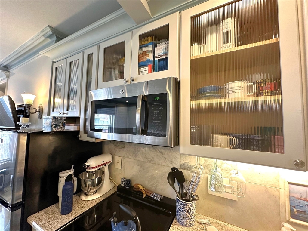 88 Charles Street, Unit 5 Boston, MA 02114 - Photo 7 of 15 a kitchen with a sink and a stove next to a window