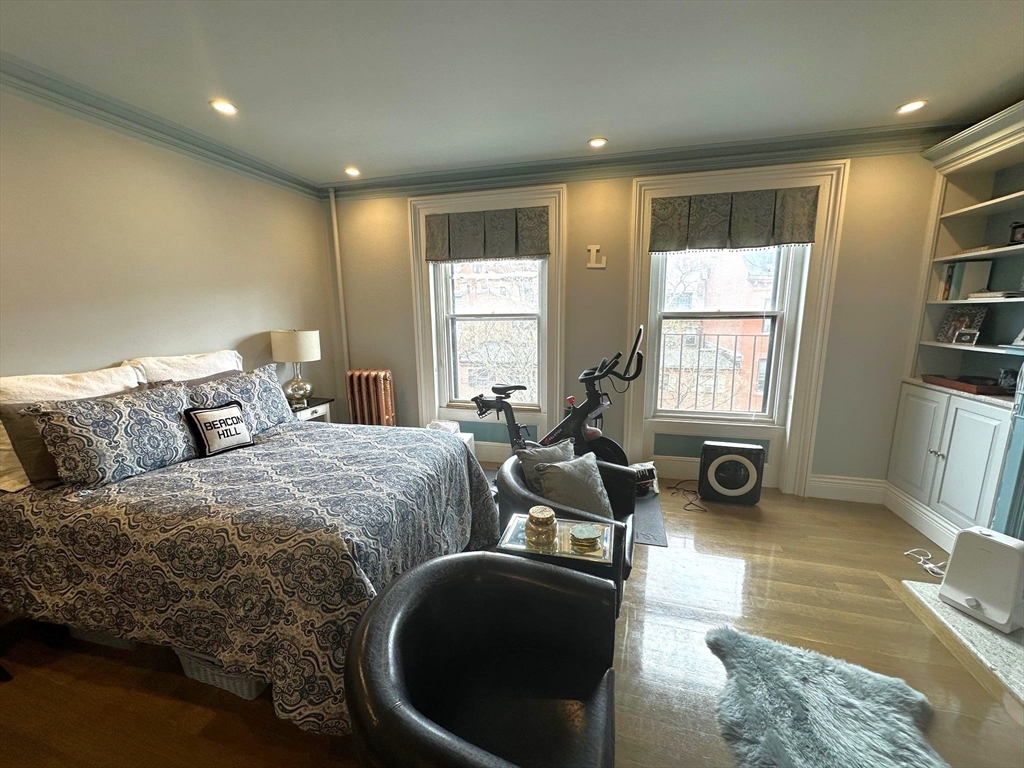 88 Charles Street, Unit 5 Boston, MA 02114 - Photo 10 of 15 a spacious bedroom with a bed a couch and a window