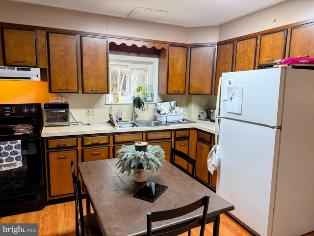 a kitchen with stainless steel appliances granite countertop a refrigerator a sink and a stove