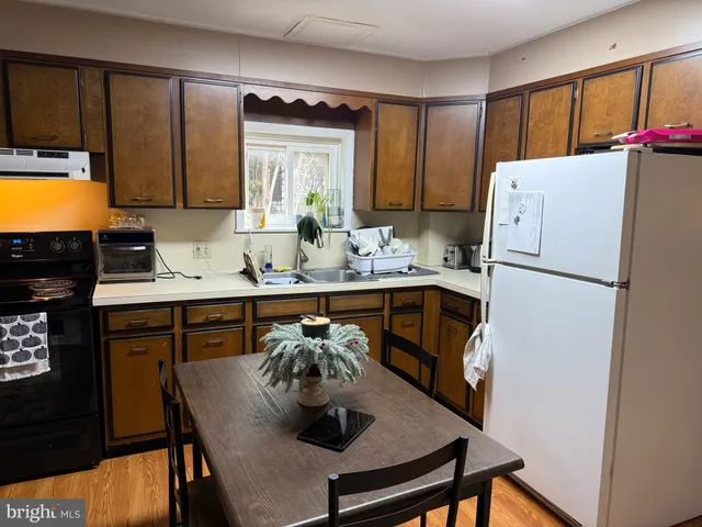 a kitchen with stainless steel appliances granite countertop a refrigerator a sink and a stove