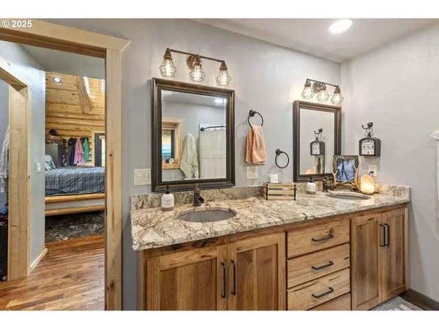 a bathroom with a granite countertop sink a mirror and shower