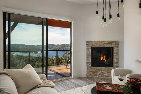 a living room with furniture a floor to ceiling window and a fireplace