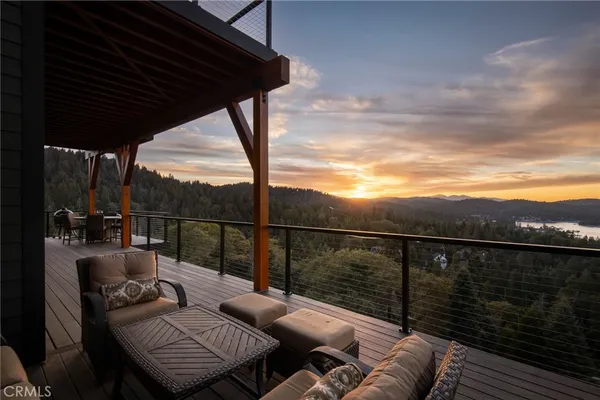 a balcony with wooden floor table and chairs