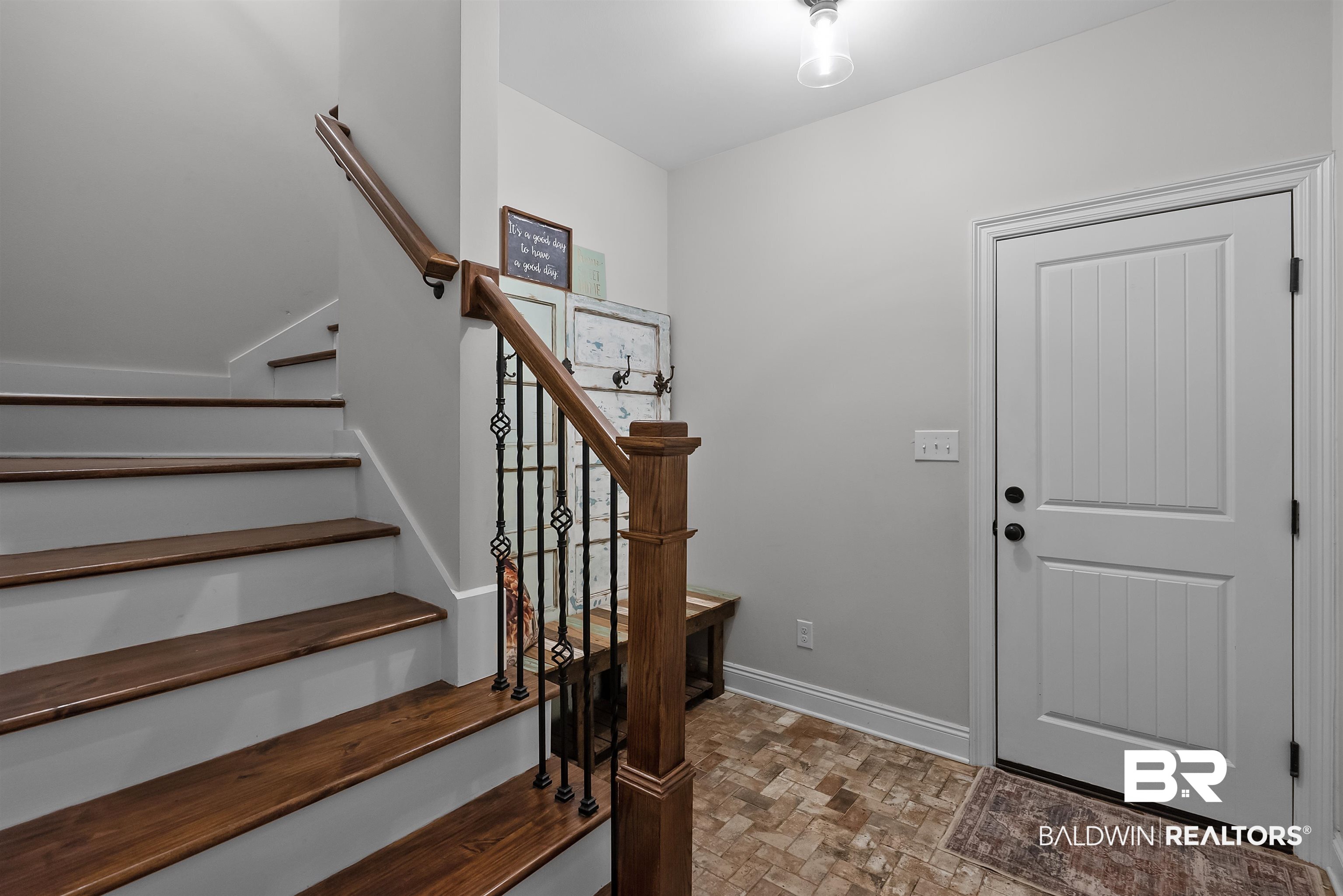 12070 Comalander Road Fairhope, AL 36532 - Photo 37 of 50 Staircase featuring wood treads and risers, with an ornamental iron and wood balustrade