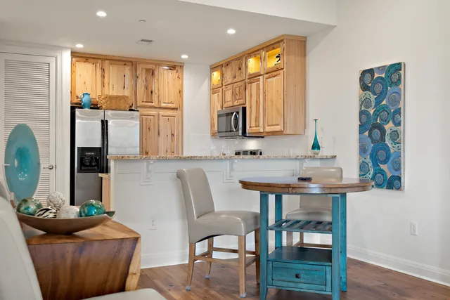 a kitchen with stainless steel appliances a table chairs and a refrigerator