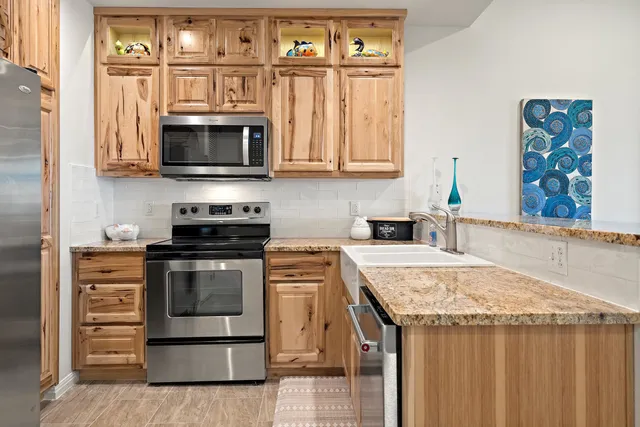 a kitchen with stainless steel appliances granite countertop a stove and a microwave