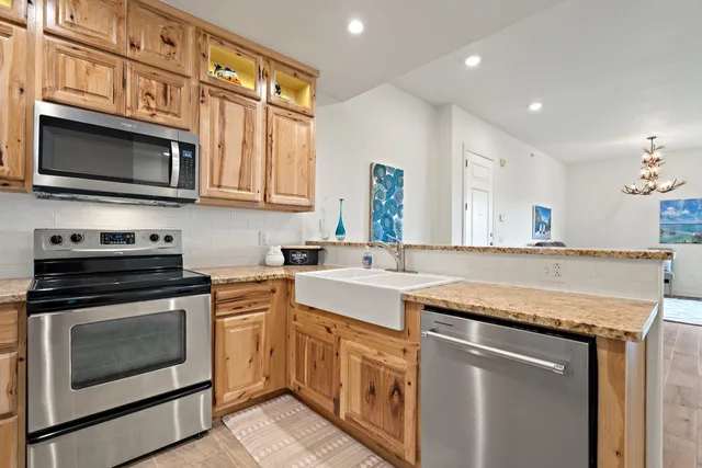 a kitchen with stainless steel appliances granite countertop a stove microwave and cabinets