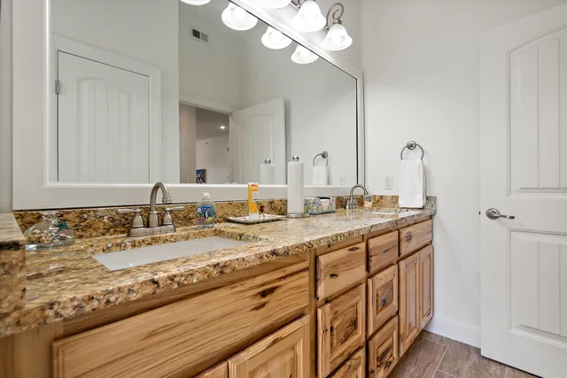 a bathroom with a granite countertop sink and a mirror