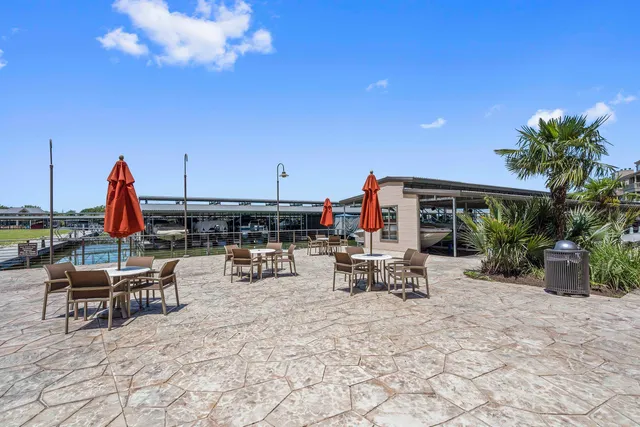 a view of a patio with a dining table and chairs with plants