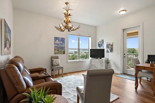 a living room with furniture a chandelier and a flat screen tv
