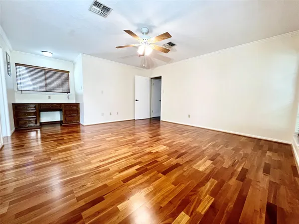 a view of an empty room with wooden floor and a fireplace